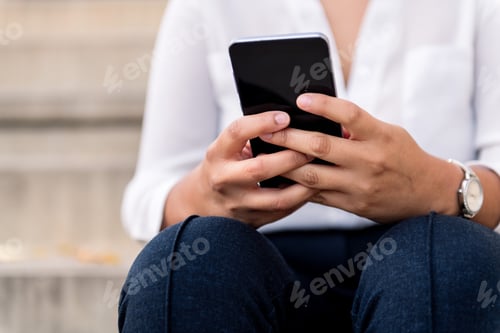 Preview: hands of a businesswoman holding a smart phone