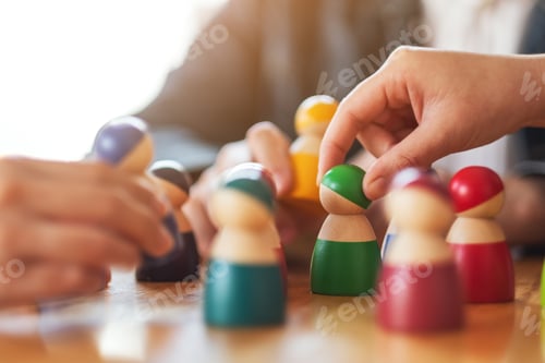 Preview: People choosing and picking up wooden figure from a group on the table
