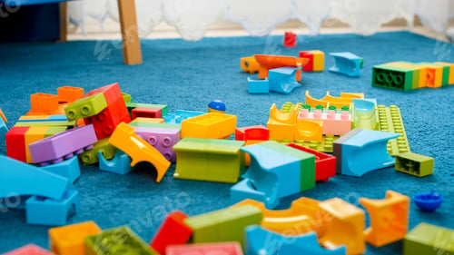 Preview: Closeup image of messy floor in playroom covered with colorful toy blocks
