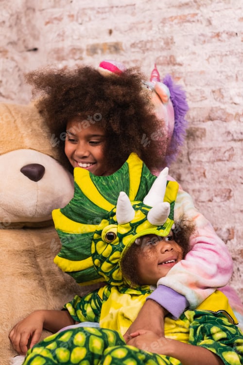 Preview: Cheerful black girls in funny costumes playing in room