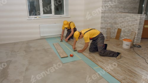 Preview: Workers laying laminate flooring.
