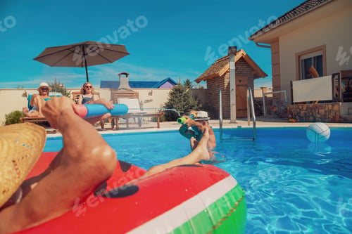 Preview: Senior people having fun splashing each other in the swimming pool