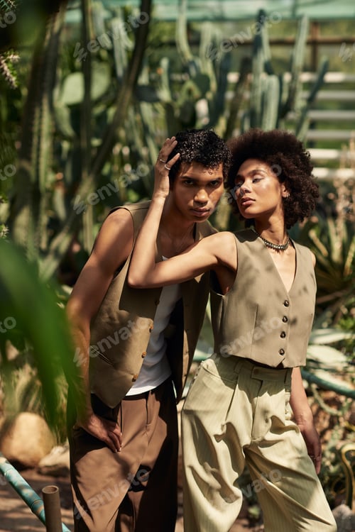 Preview: Young couple sharing a romantic moment in a lush greenhouse filled with vibrant greenery