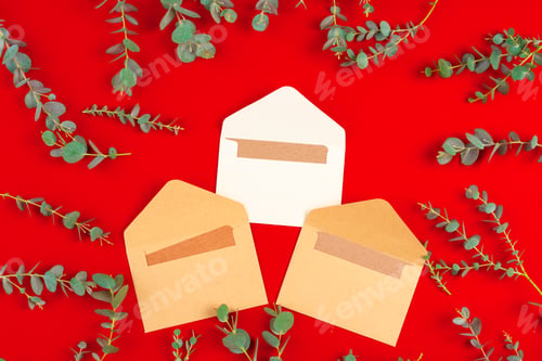 Preview: Craft envelope with letter inside on red background with plant branches