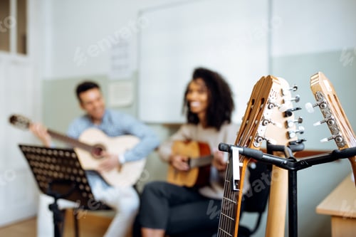 Preview: Man and woman playing guitar in studio