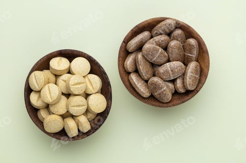 Preview: Alternative medicine tablets on a wooden spoon.