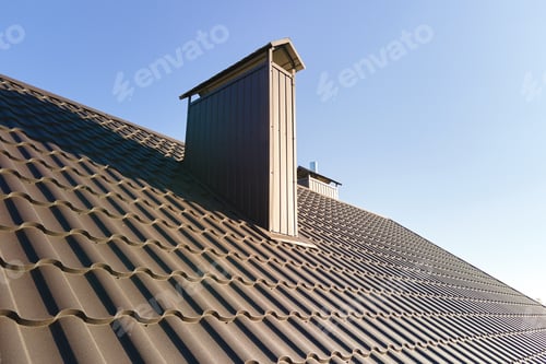 Preview: Chimney on house roof top covered with metallic shingles under construction.