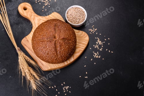 Preview: Fresh baked brown bread with ears and grains of wheat