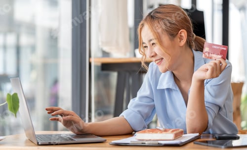 Preview: Happy attractive Asian woman using laptop and creditcard for online shopping, onlne banking concept.