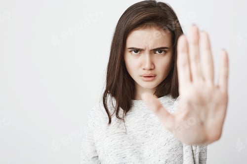 Preview: Portrait of beautiful european woman with serious and angry expression stretching one hand in hold