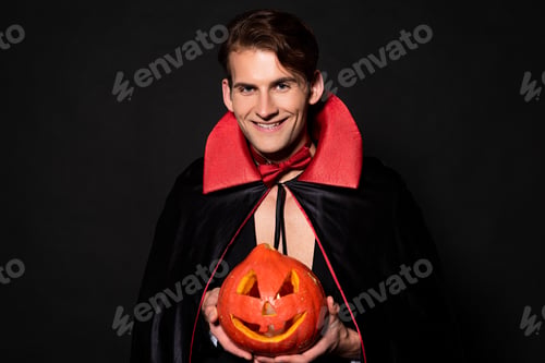 Preview: happy man holding halloween pumpkin isolated on black