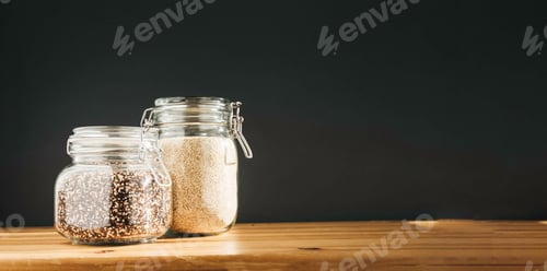 Preview: White and brown raw organic quinoa in glass storage containers. Healthy cooking, clean eating, zero