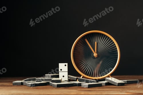 Preview: Domino tiles and clock on wooden table against black background