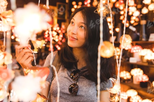Preview: Beautiful asian girl portrait looking at lights in a shop
