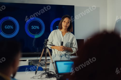 Preview: Asian female team leader using chart on a big digital screen during a meeting