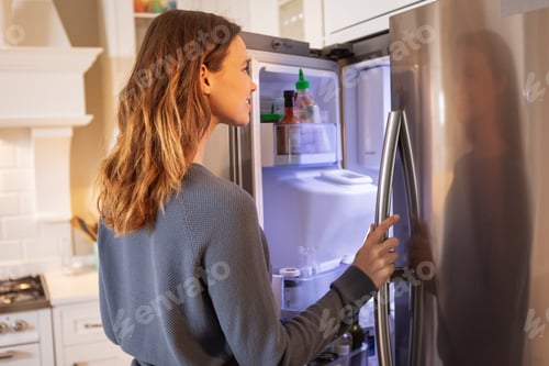 Preview: Woman opening the fridge at home