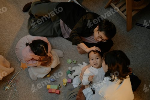 Preview: Asian Parents and Children Spending Evening Together Playing on Living Room Floor