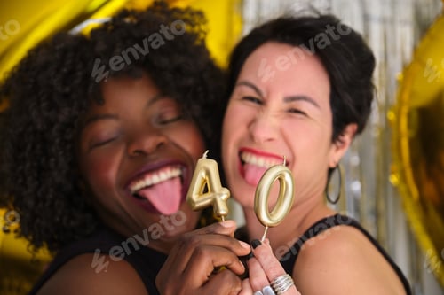 Preview: Two multiracial women in a 40 birthday party with 40 birthday golden candles.