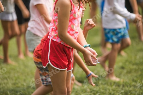 Preview: Group of happy, cheerful children playing in waterballoon game in the park and having fun together