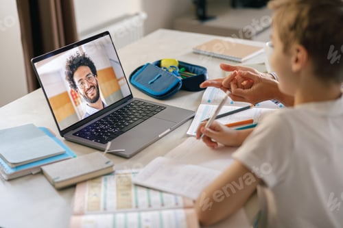 Preview: Schoolboy attending distance virtual class and listen teacher from home. E-education