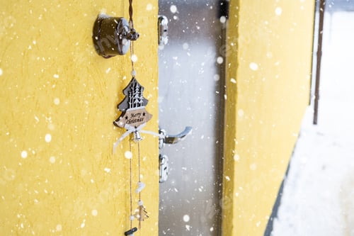 Preview: A Christmas tree-shaped pendant with the inscription merry Christmas hangs on the front door of the