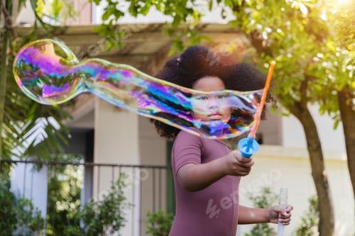 Preview: Little girl blowing soap bubbles. preschool kid, enjoy happy time in the park