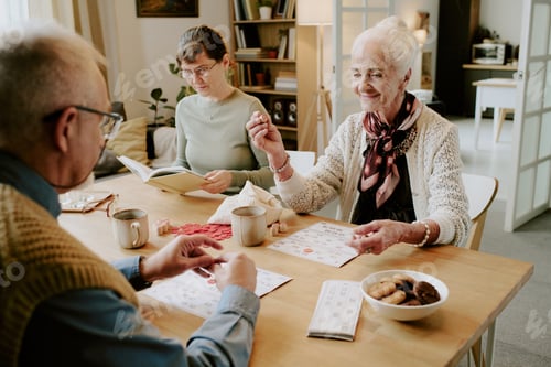 Preview: Senior Woman Playing Bingo with Senior Man at Table