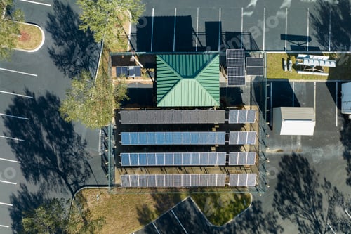 Preview: Aerial view of blue solar photovoltaic panels mounted on fenced backyard