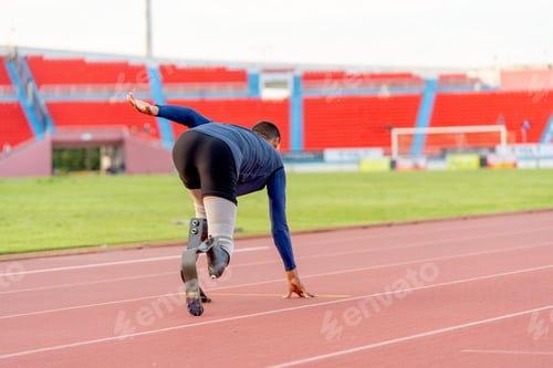 Preview: Back of Sport man athlete prosthesis legs run on the track in the stadium with day light.