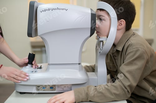 Preview: Ophthalmologist checking vision of child with autorefractor in clinic