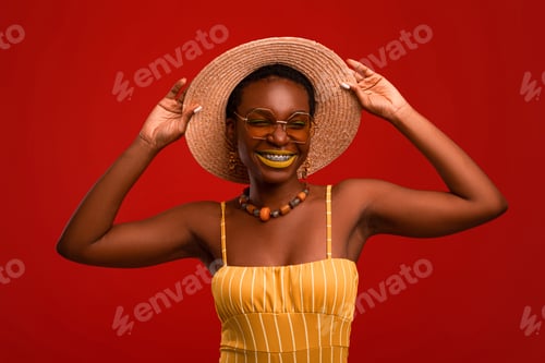 Preview: Happy black woman in summer outfit posing on red