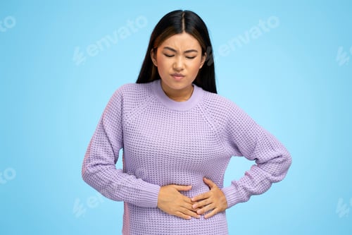 Preview: Portrait of beautiful brunette asian young woman standing and feeling pain on her stomach
