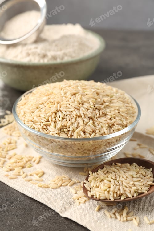 Preview: Brown rice, flour and sieve on grey table, closeup