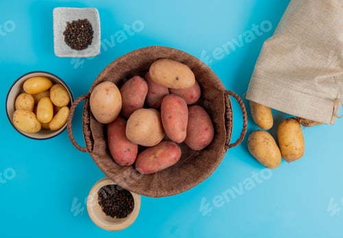 Preview: top view of potatoes in basket and in bowl with other ones spilling out of sack and black pepper