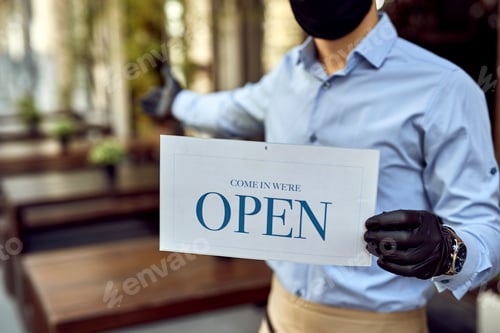 Preview: Close-up of cafe owner holding open sign after coronavirus epidemic.