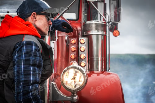 Preview: Professional Truck Driver Leans Against Vintage Truck While Contemplating the Road Ahead