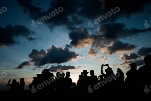 Preview: Group of people at sunrise photographing the sun, silhouettes of people