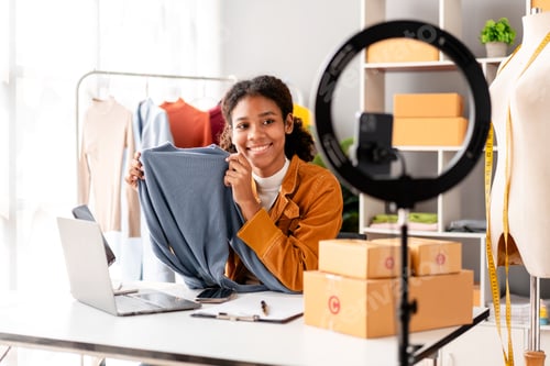 Preview: Woman designer entrepreneur showing clothes product on live online social media streaming