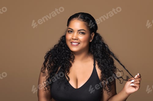 Preview: Smiling brazilian body positive lady flirting and touching her beautiful curly hair, smiling at