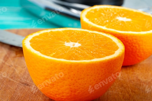 Preview: Cut oranges on wooden board on table
