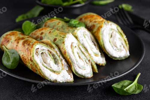 Preview: Savory crepes with spinach and feta cheese on black background