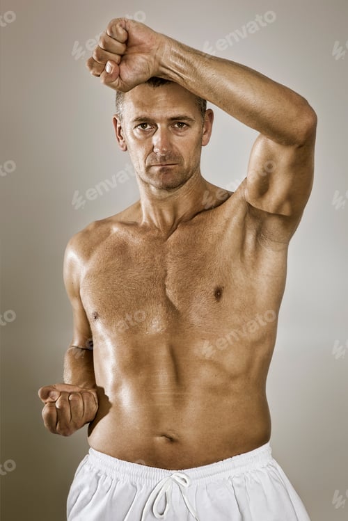 Preview: Muscular Man Demonstrating Martial Arts Move in Studio