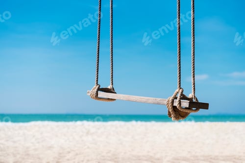 Preview: Travel and summer background, wooden swing on the beach with white sand and blue sky.