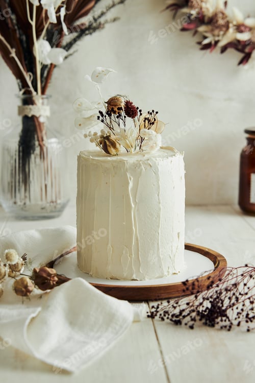 Preview: Closeup shot of delicious Boho ombre cake with dry flowers on a white table
