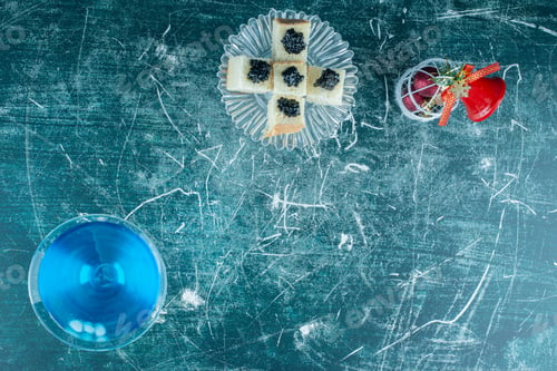 Preview: A glass cup of blue drink with pastries