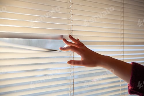 Preview: Woman's hand taking a peak through the window blinds.