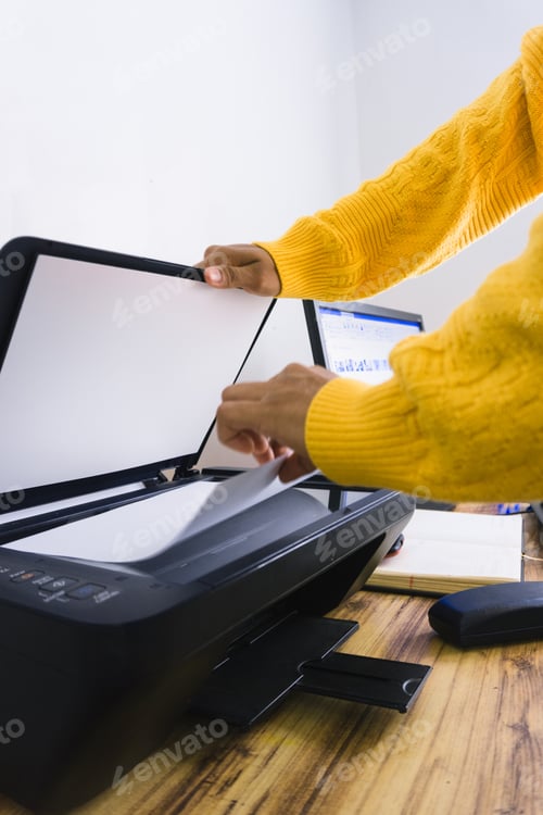 Preview: Vertical shot of a person using a scanner on the desk at home