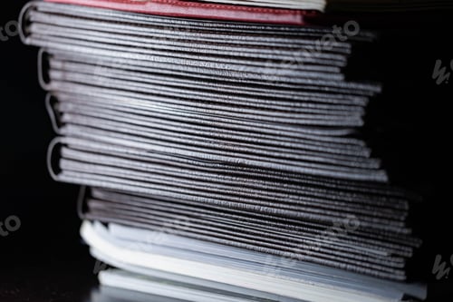 Preview: Close-up of a stack of dark-colored books in low light