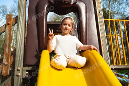 Preview: Active blonde little girl playing on a playground