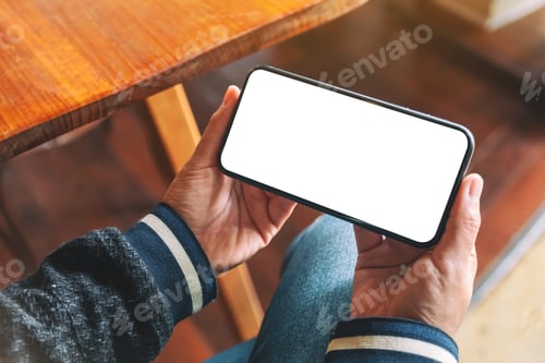Preview: Mockup image of hands holding black mobile phone with blank desktop screen
